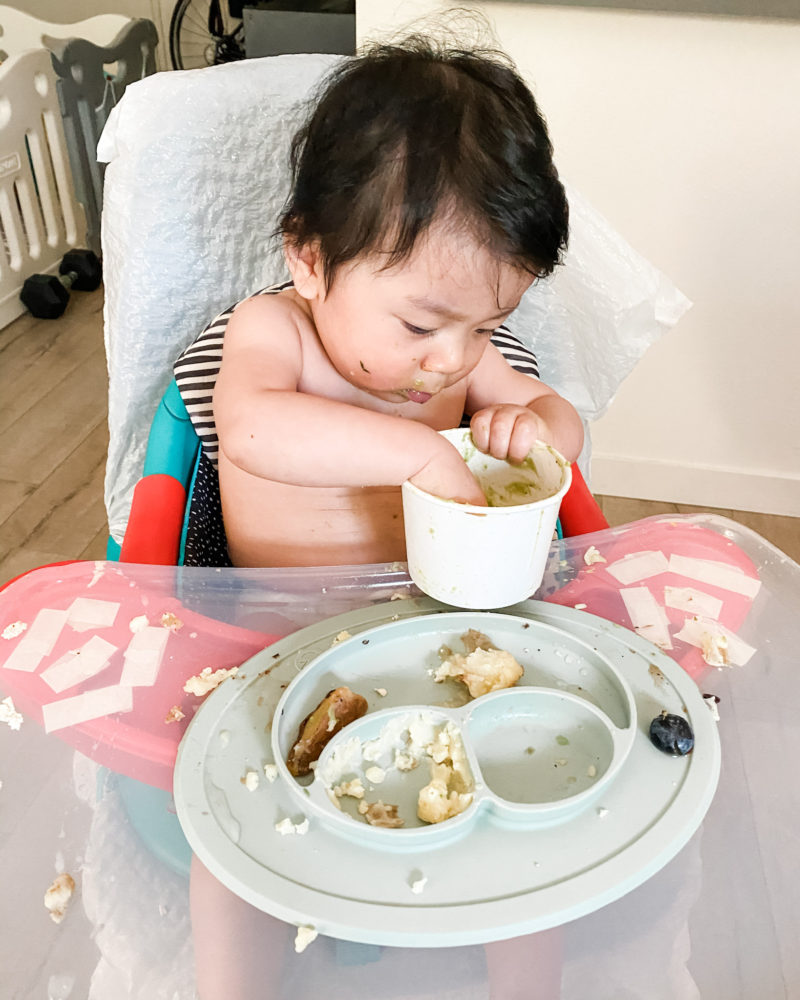 Baby looking for guacamole in a container